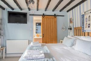 a bedroom with a white bed with towels on it at Hawthorn Farm Guest House in Buxton