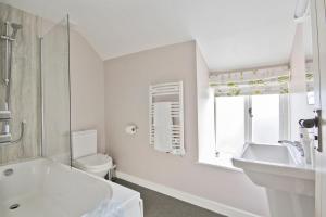 Baño blanco con lavabo y aseo en Hawthorn Farm Guest House en Buxton