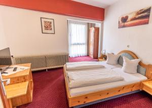 a bedroom with two beds and a desk at Hotel Pension Löwen in Sulz in Sulz