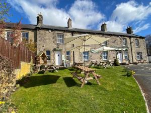 um edifício com mesas de piquenique em frente em The Beresford Arms em Morpeth