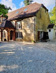 an old stone house with a driveway in front of it at Villa confortable à Carlux avec piscine privée et jardin in Carlux