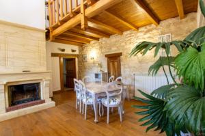 a dining room with a table and chairs and a fireplace at Villa confortable à Carlux avec piscine privée et jardin in Carlux