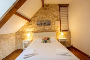a bedroom with a large bed in a stone wall at Villa confortable à Carlux avec piscine privée et jardin in Carlux +31 photos