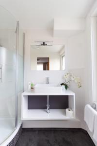 La salle de bains blanche est pourvue d'un lavabo et d'une douche. dans l'établissement Hotel Pension Löwen in Sulz, à Sulz