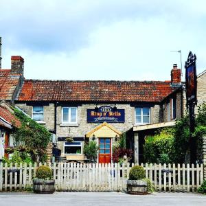 una cerca blanca frente a un edificio en Ring O Bells Hinton Blewett en Bristol