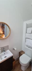 uma casa de banho com um WC branco e um espelho. em Ring O Bells Hinton Blewett em Bristol