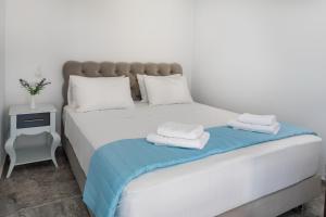 ein Schlafzimmer mit einem Bett mit zwei Handtüchern darauf in der Unterkunft Plori - Molos Apartments in Loutro
