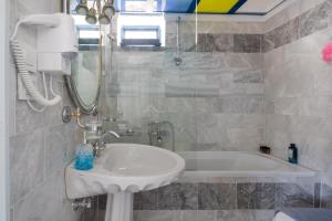 a bathroom with a sink and a bath tub at Plori - Molos Apartments in Loutro