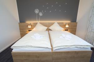 uma cama grande com duas almofadas brancas em Landhotel Hopster em Rheine