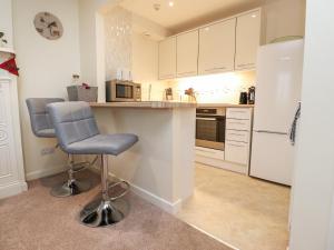 een keuken met een aanrecht en een stoel erin bij Coach House Cottage in Carnforth