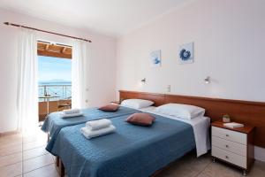 een slaapkamer met een blauw bed en handdoeken bij Corfu Shell Apartments in Barbati