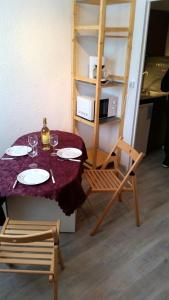 a table with a bottle of wine and two chairs at Studio avec jardin clos et wifi a La Salle les Alpes in La Salle Les Alpes