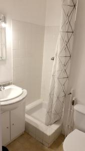 a white bathroom with a tub and a sink at Studio avec jardin clos et wifi a La Salle les Alpes in La Salle Les Alpes