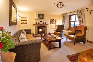 a living room with two couches and a fireplace at Finest Retreats - Bretherdale Hall in Tebay