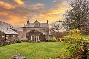 una vieja casa de piedra con un patio delante en Finest Retreats - Bretherdale Hall, en Tebay