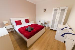 - une chambre blanche avec un lit et une couverture rouge dans l'établissement Modern and Spacious House Perfect for Teams, à Luton