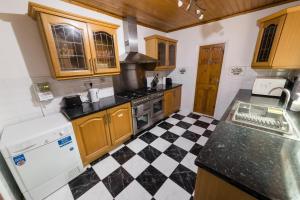 a kitchen with a black and white checkered floor at Modern and Spacious House Perfect for Teams in Luton