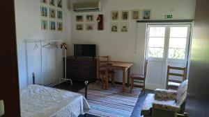 1 dormitorio con cama, escritorio y ventana en Casa do Lago, en Vila de Rei