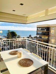 balcón con mesa y vistas al océano en Apartamento de lujo Almadraba Benicasim, en Benicàssim