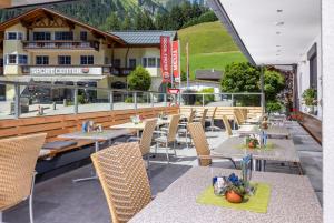 a restaurant with tables and chairs on a patio at Dorfstube in Holzgau