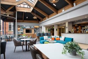 an office lobby with blue couches and tables at Holiday Inn Bolton Centre by IHG in Bolton