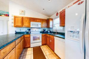 a kitchen with wooden cabinets and white appliances at Seaside Searenity in Indian Pass +11 photos