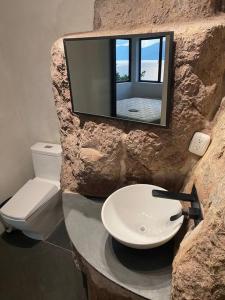 JaibalitoにあるRustic Charm Cliffside Retreatの石造りのバスルーム(洗面台、トイレ付)