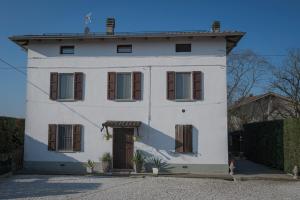 une maison blanche avec des fenêtres marron et une porte dans l'établissement La Fossetta B&B, à Torrile