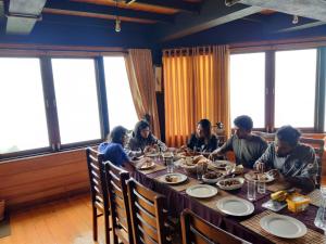 a group of people sitting at a table eating food at Amansara Bungalow in Nuwara Eliya