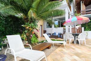 patio con sedie, tavolo e ombrellone di Chalés Mirante da Lagoinha a Ubatuba