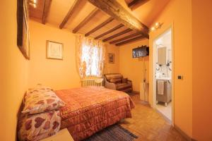 a bedroom with a bed and a chair in a room at La Fossetta B&B in Torrile