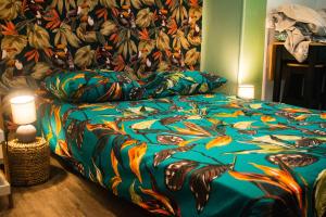 a bedroom with a bed with a colorful blanket at Les studios de l'hyper centre ville in Pau