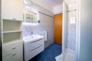 a bathroom with a sink and a shower at Apartments Rajska Plaza (129) in Lopar +65 photos
