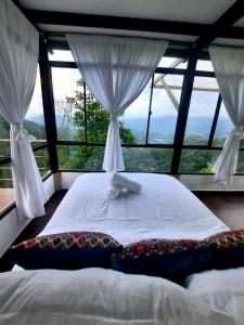 łóżko w pokoju z dużym oknem w obiekcie El paraíso de Butulu w mieście La Vega