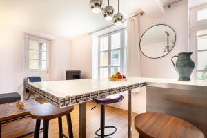 eine Küche mit einem Tisch, Stühlen und einem Spiegel in der Unterkunft La suite versaillaise à 5min du Palais in Versailles