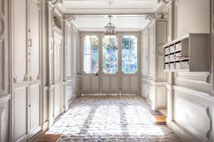 einen verzierten Flur mit Tür und Fenster in der Unterkunft La suite versaillaise à 5min du Palais in Versailles