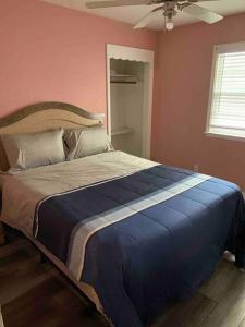 a bedroom with a large bed with a blue and white blanket at Remodeled House Minutes to Falls Attractions in Niagara Falls