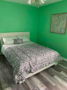 Dormitorio verde con cama con pared verde en Remodeled House Minutes to Falls Attractions, en Niagara Falls
