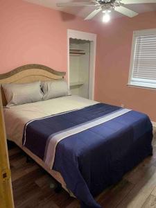 a bedroom with a large bed with a blue blanket at Remodeled House Minutes to Falls Attractions in Niagara Falls