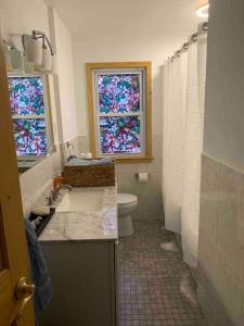 a bathroom with a toilet and stained glass windows at Remodeled House Minutes to Falls Attractions in Niagara Falls