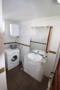un bagno con lavandino e lavatrice di Parque Santiago II Villa 2 Tenerife Rental & Sales a Playa de las Americas