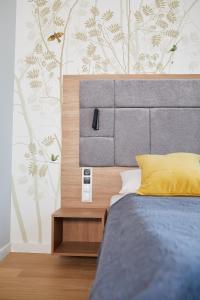 1 dormitorio con 1 cama y una pared con árboles en Aparthotel Park - By The Sea en Gdynia