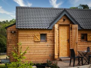 a wooden cabin with a black roof at Cab'ânes du Pibeste in Ségus