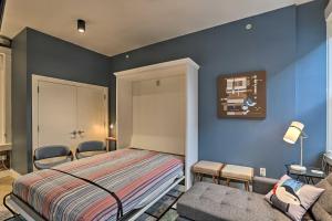 ein Schlafzimmer mit blauen Wänden und einem Bett und einem Sofa in der Unterkunft Sleek Studio Near Dtwn Dining and Entertainment in Cincinnati