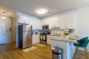 a kitchen with white cabinets and a stainless steel refrigerator at *King Bed Ideal For Long Stays w/ Foosball Table!* in Carteret
