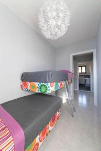 a room with a bed and a chandelier at Luxurious attic-swimming pool in Riva di Solto