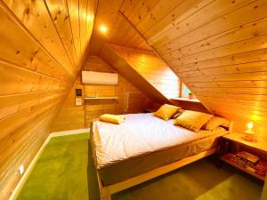 1 dormitorio con 1 cama en una habitación de madera en Cilensis Spa, en Sulistrowiczki