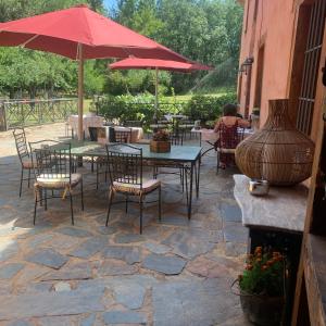 a patio area with tables, chairs and umbrellas at Molino De La Ferrería in Villacorta