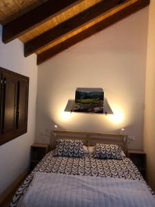 a bedroom with a bed and a painting on the wall at Casa adosada familiar con jardín y piscina in Villanúa