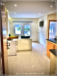 een keuken met een eiland in het midden van een kamer bij Hôtel Réstinga Martil in Martil